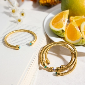 Detail of gold ribbed bangles featuring natural malachite and lapis stone inlays