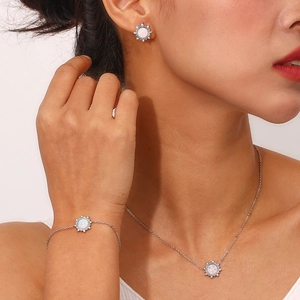 Silver stainless steel jewelry set with sun pendant and white opal stone on a model