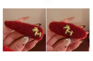 Dettaglio macro di fermagli per capelli in mohair rosso con ciondolo a cavallo