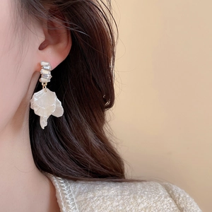 Close-up of elegant flower pearl earring with crystals and rectangular gemstones on model