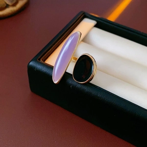 Detailed macro view of an asymmetric ring with purple oval stone and black accent