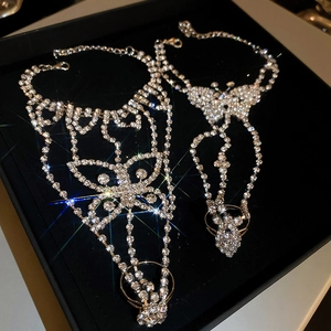 Macro detail of silver butterfly ring-bracelet combo with sparkling rhinestones on velvet