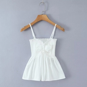 Détail d'un caraco blanc avec smocks, nœud décoratif et ourlet à volants élégant
