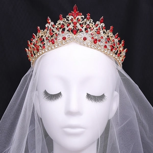 Luxurious gold bridal crown with red and clear crystals on a white veil