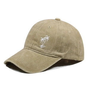 Detailed side view of khaki washed denim baseball cap featuring white palm tree embroidery