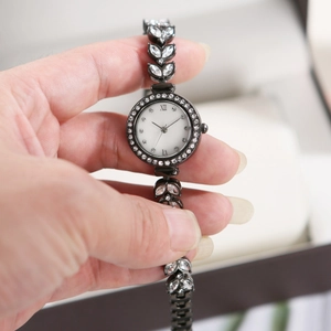 Close-up of luxury leaf-shaped metal watch strap inlaid with rhinestones for women