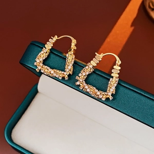 Macro shot of gold-plated U-shaped earrings with sparkling cubic zirconia inlay