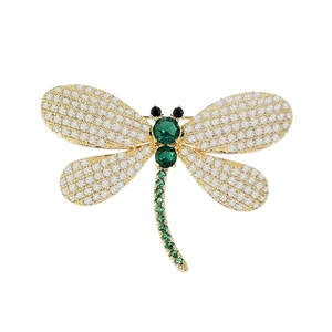 Luxury dragonfly brooch featuring green and white crystals on a gold-plated base setting.
