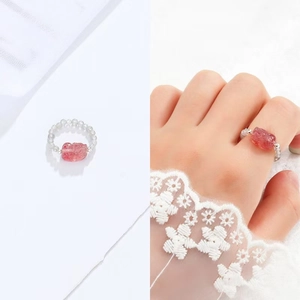 Detail view of pink strawberry crystal beaded ring on model and white background