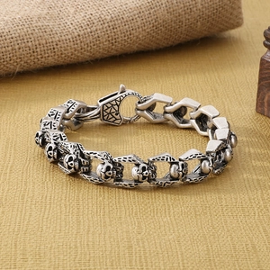 Close-up of vintage silver skull bracelet with punk gothic links and textured clasp
