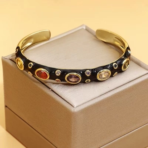 Detail of a black enamel cuff bracelet with colorful cubic zirconia on a jewelry box
