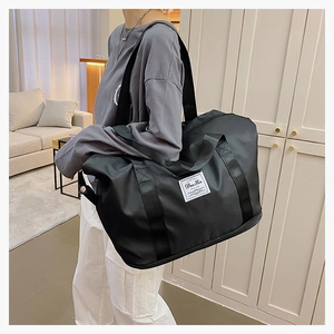 Detail of high-density black nylon travel bag with reinforced handles and logo label