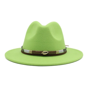 Detail of green fedora hat featuring a brown leather band and shell accent