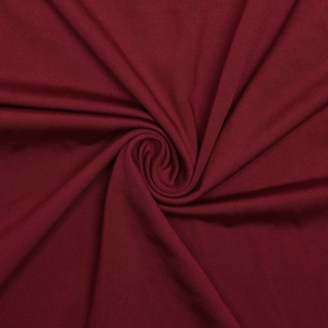 Detailed view of dark red ribbed knit fabric texture with elegant spiral draping