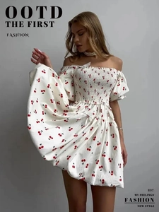 Detailed close-up of a square neck puff sleeve dress with a red cherry print and elastic waist