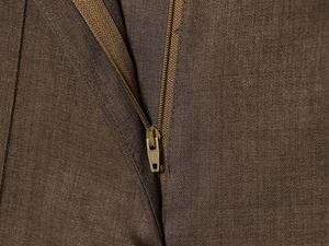 Close-up of golden metal zipper and brown textured fabric on high waist trousers
