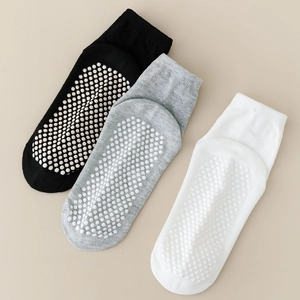 Detail of baby socks showing non-slip silicone grippers on black, grey, and white soles