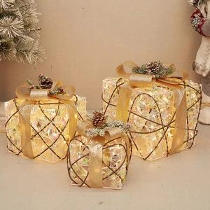 Three-piece glowing Christmas gift boxes with pine cones and golden bows for decor