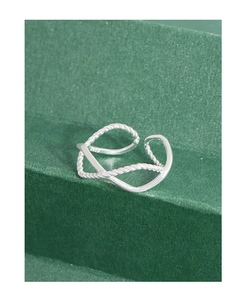 Macro shot of S925 sterling silver ring showing twisted rope texture and polished cross design