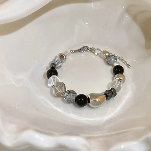 Detailed shot of dark black crystal beads and silver accent beads on a layered bracelet