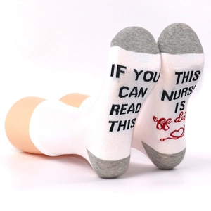 Detail of socks with funny nurse off duty message and heart stethoscope on soles