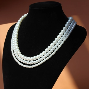 Three-layer pearl necklace with graduated pearl diameters on a black neck display