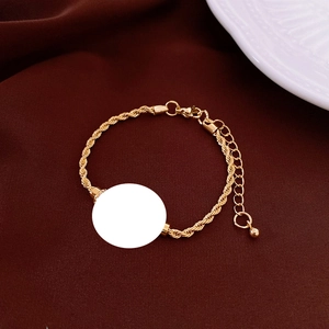 Detail of gold twisted rope bracelet with a customizable round blank charm for engraving