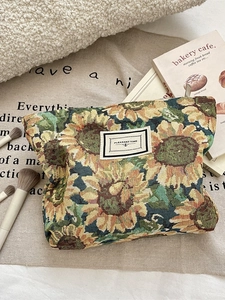Retro sunflower jacquard makeup bag with Pleasant Time label on warm beige backdrop