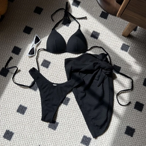 Detailed view of black textured high waist bikini three-piece set with a matching sarong