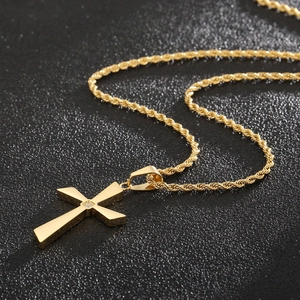Detailed view of a gold-plated cross pendant with a central sparkling stone on a rope chain