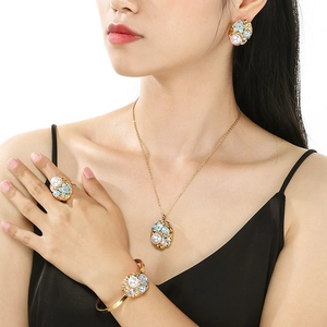 Luxury gold stainless steel jewelry set with pearls and enamel flowers on a model