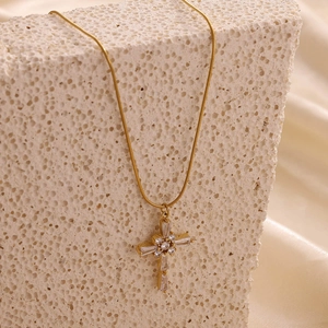 Collier avec pendentif croix dorée et pierres de zircon sur une base en pierre de texture