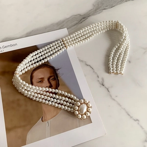Detail of four-layer pearl belt featuring a large oval centerpiece with rhinestone trim