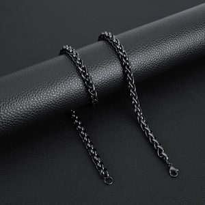 Detailed view of black stainless steel keel chain with lobster clasp on leather texture