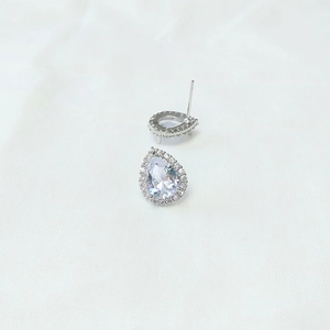 Detailed view of silver teardrop earrings with pear-cut cubic zirconia and pavé halo stones