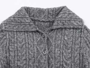 Dettaglio cardigan grigio in maglia a trecce con collo a revers e bottoni scuri