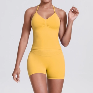 Close-up of ginger yellow seamless yoga set featuring ruched V-neck sports bra and shorts