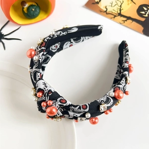 Detail of Halloween headband with skull pattern, orange pearls and rhinestones decoration