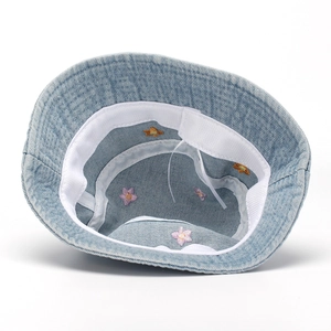 Close-up of denim sun hat interior with floral embroidery and adjustable drawstrings
