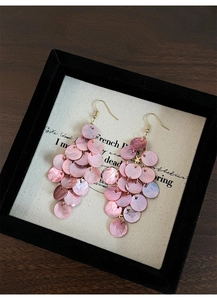 Detail of pink shell petals layered in a long fringe tassel with gold earring hooks