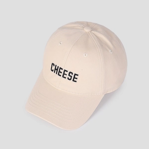 Nahaufnahme der schwarzen CHEESE-Stickerei auf einer cremefarbenen Baumwoll-Baseballkappe