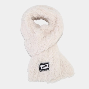 Gros plan sur une écharpe en peluche blanc cassé avec écusson LOVE et texture douce en fausse fourrure