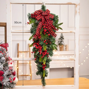 90cm Christmas Teardrop Swag with red berries pine cones and plaid bow on white window