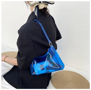Blue transparent PVC shoulder bag displayed as a trendy crossbody on a black blazer