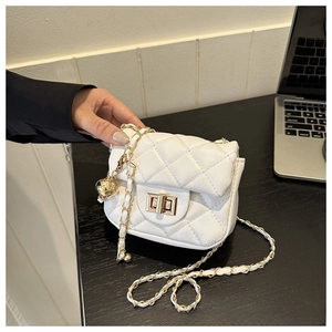 Close-up of quilted mini crossbody bag with gold turn-lock and ball chain detail