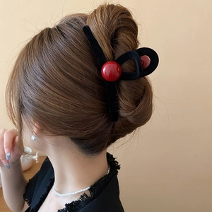 Macro detail of red beads on flocking shark clip styled on hair for an elegant look