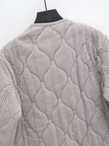 Dettaglio trapuntatura a onde su giacca in twill grigio viola chiaro con scollo rotondo