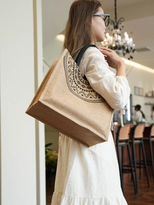 Detail of large jute tote bag with black tribal pattern and canvas shoulder straps