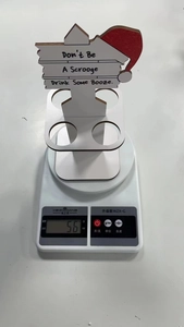Mini wooden Christmas bottle holder showing 56g weight on a scale for shipping detail