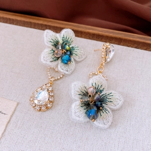Detail of vintage flower earrings with embroidery petals and sparkling rhinestones